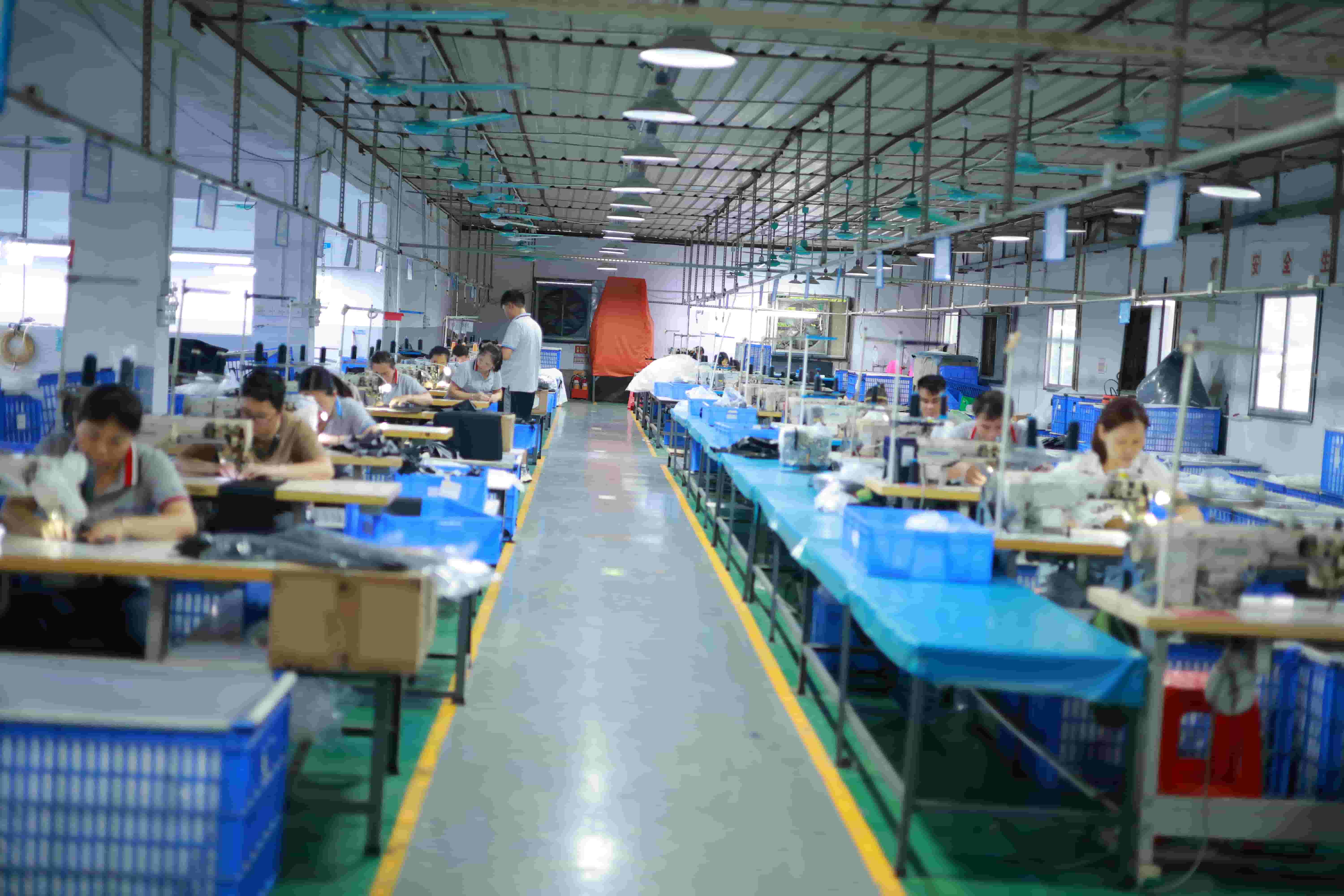 Clean zoned inline assembly floor at Sealock factory with supervisors checking welded seams for voids